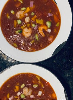 seafood gazpacho in two white soup bowls with a black rim