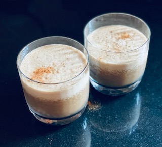 Frothy light brown frozen cocktail with a dusting of cinnamon