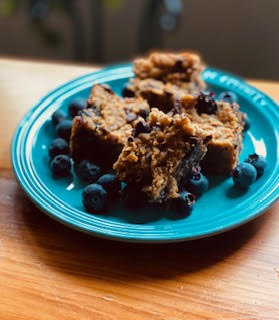 small teal blue plate with four oatmeal squares and fresh blueberries scattered